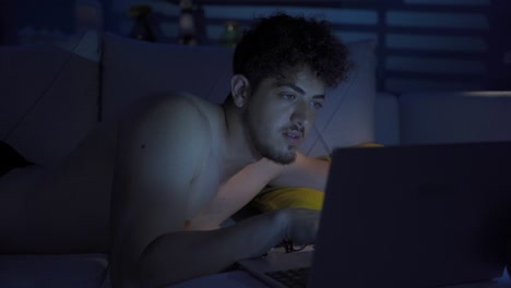 Young-man-is-using-laptop-at-night.